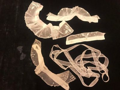several pieces of white lace on a black background