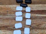 several black and white stones are arranged on a wooden table