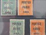 quatre timbres différents, de couleurs variées, sur un fond noir
