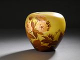 un vase jaune orné d'un motif floral posé sur une table