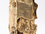 a gold statue of a man holding a book