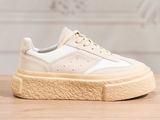 a close up of a pair of white sneakers on a wooden table
