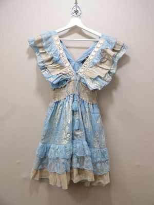 blue and white dress hanging on a hanger against a wall