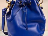un sac seau bleu posé sur une table blanche