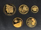 four gold coins with different designs on them on a black surface