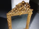 a mirror with a gold frame on a white surface