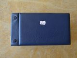 un étui en cuir bleu sur lequel est collé un autocollant blanc