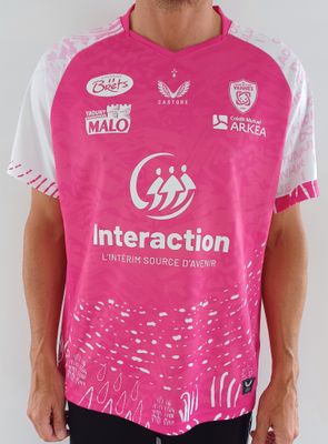 un homme qui porte une chemise rose et un pantalon noir
