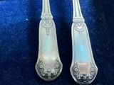 two spoons that are sitting on a blue cloth