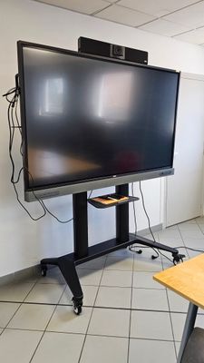 un téléviseur à écran plat posé sur un support dans le coin d'une pièce