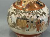 a vase with a painting on it sitting on a table