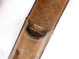 a close up of a brown leather belt with a tag on it