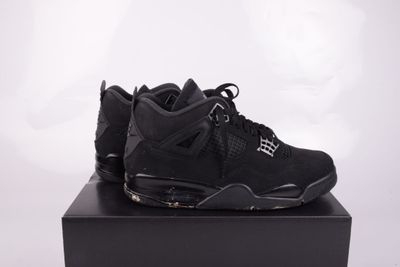 une paire de baskets noires posée sur une boîte noire