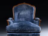 une vieille chaise dont l'assise est recouverte d'un tissu bleu