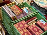many boxes of books on a table with a hat on top