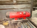 un réservoir rouge posé sur une palette dans un garage