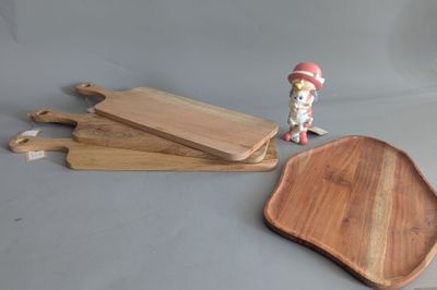 three wooden cutting boards and a small figurine on a table