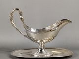 a silver plate with a saucer and a spoon on it