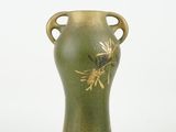 a green vase with a gold decoration on it