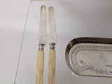 two knives and a knife holder on a glass table