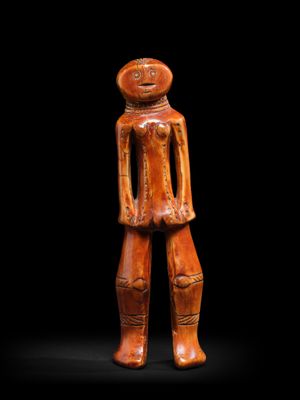 une figurine en bois représentant un homme, les mains dans les poches