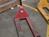 a fork lifter sitting in a warehouse with pallets in the background