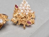 two pairs of gold and pearl earrings on a gray surface