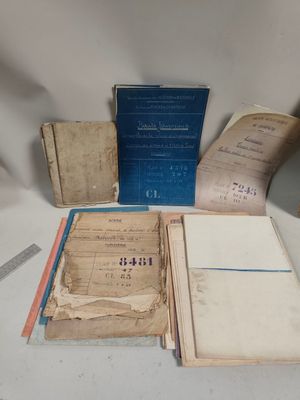 quelques vieux livres sont posés sur une table, avec une paire de ciseaux à côté