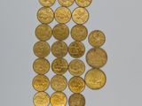 a close up of a pile of gold coins on a white surface