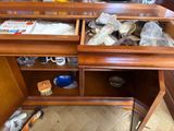 a wooden desk with a drawer full of items in it