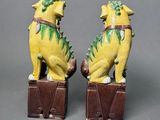 pair of yellow dog figurines sitting on top of a wooden box