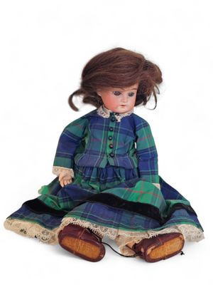 a close up of a doll sitting on a white surface