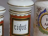 three ceramic jars with decorative designs are lined up on a table