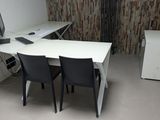 un bureau avec deux chaises et un ordinateur dessus