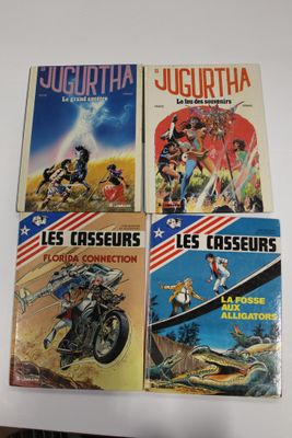 quatre livres posés sur une table recouverte d'une nappe blanche