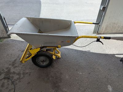 une brouette avec un manche jaune dans la rue