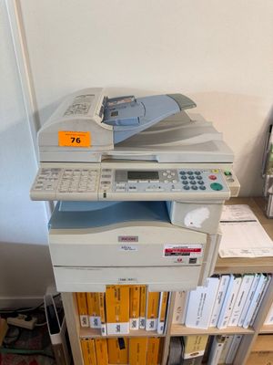 une imprimante multifonction posée sur une bibliothèque