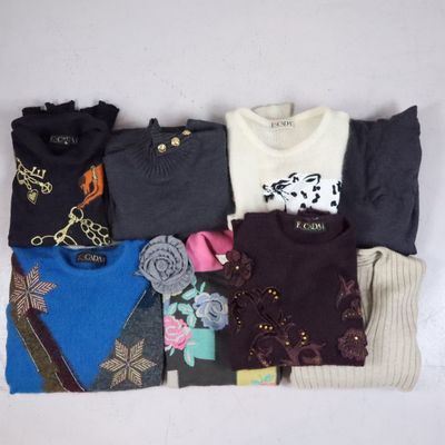 a lot of sweaters that are laying on the table