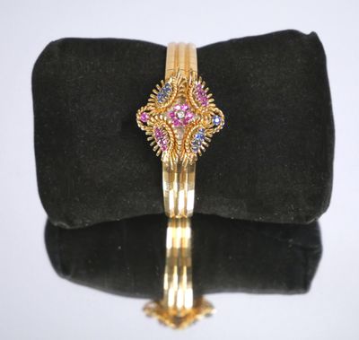 une photo d'un bracelet en or orné de pierres roses et bleues