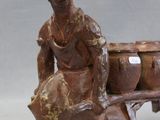a statue of a man sitting on a bench with a suitcase