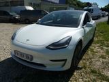 une Tesla Model 3 blanche garée sur un parking