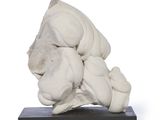 a white sculpture of a dog on a black base