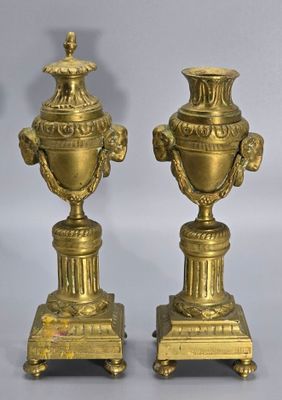 une paire de vases anciens en laiton sur socles, sur fond gris