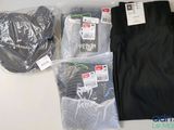 Deux paires de pantalons noirs et un pantalon noir sont posés sur une table