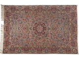 un tapis persan ancien avec un motif floral et des franges