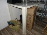 une petite table sur laquelle est posé un micro-ondes