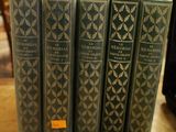 Plusieurs livres sont empilés sur une table dans une bibliothèque