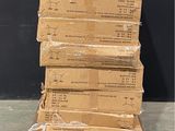 une pile de cartons posée sur une palette devant un mur noir