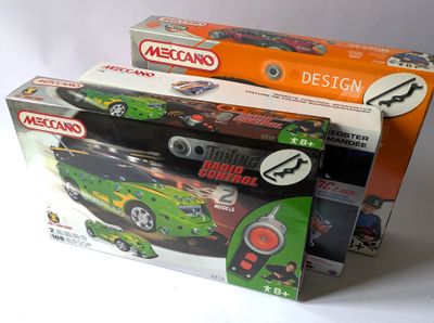 trois boîtes de petites voitures posées sur une surface blanche