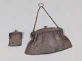 an old purse with a chain hanging from it ' s side and a small purse with a chain hanging from it ' s side